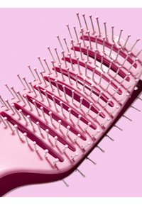 Brosse à cheveux rose au design courbé, dotée de poils blancs et de pointes arrondies. La texture en plastique lisse améliore la maniabilité.