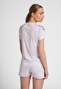 Camiseta atlética blanca de manga corta, con detalles azules en los hombros. Textura suave, material ligero y diseño ajustado.