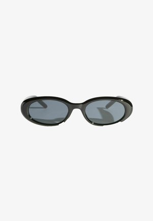 Sorte ovale solbriller med mørke tonede linser og tykke blanke stel på hvid baggrund.