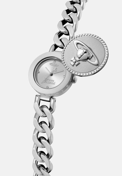 Montre argentée avec un cadran rond et un bracelet à maillons. Comprend un charme circulaire proéminent avec un design de planète et des accents texturés.