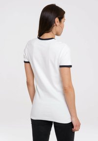 Weißes kurzärmliges T-Shirt mit schwarz geripptem Kragen und Saum, taillierte Passform und glatte Textur, von hinten betrachtet.