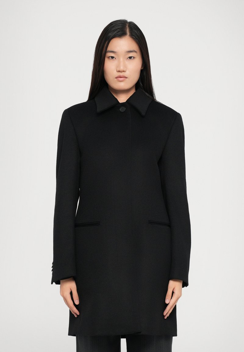 Black wool coat with a classic collar, single button closure, and two front pockets. Features long sleeves and a tailored fit.