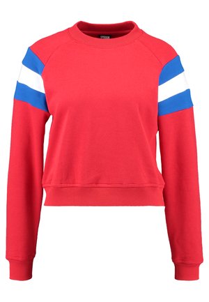 Červený zkrácený svetr s ribbed manžetami a lemem. Obsahuje modré a bílé proužkované akcenty na rukávech. Měkká bavlněná směs, ležérní design.
