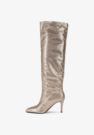 Knee-high stiletto laars in metallic goud met een spitse neus, versierd met rhinestones voor extra textuur en glans. Overal een gladde afwerking.