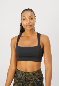 Sujetador deportivo negro corto con tirantes anchos y escote cuadrado, hecho de un material suave y flexible, que ofrece una silueta ajustada.