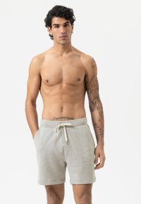 Shorts en coton gris avec une taille à cordon, dotés de poches latérales et d'un design décontracté. Le tissu a une finition douce et texturée.