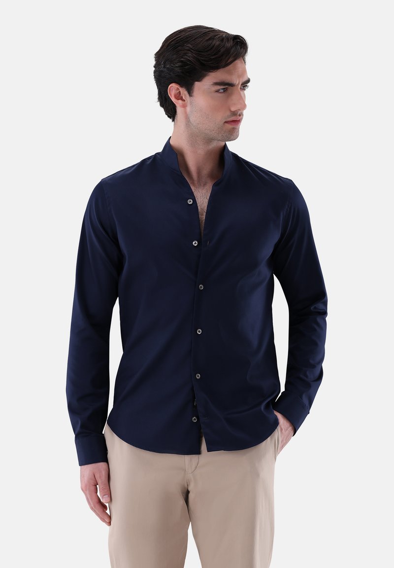 Camicia a manica lunga blu navy con colletto alla cinese, realizzata in tessuto morbido, dotata di chiusura con bottoni e design aderente.