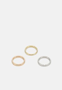 Tre anelli metallici in oro rosa, oro e argento. Ogni anello presenta una finitura liscia e una forma circolare semplice senza decorazioni.