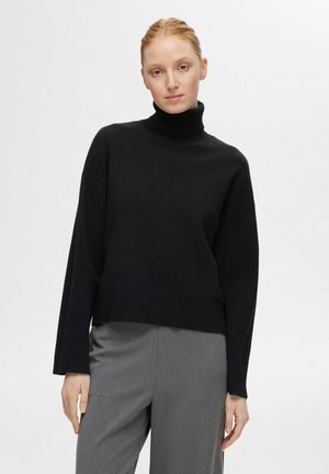 Black turtleneck sweater made of knit fabric. Features a relaxed fit, wide sleeves, and a ribbed texture at the collar and hem.