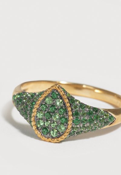 Χρυσό δαχτυλίδι με κεντρικό στοιχείο σε σχήμα σταγόνας, επενδεδυμένο με ανοιχτόχρωμους και σκούρους πράσινους πολύτιμους λίθους, πλαισιωμένο από ένα χρυσό πλεγμένο σχοινί.