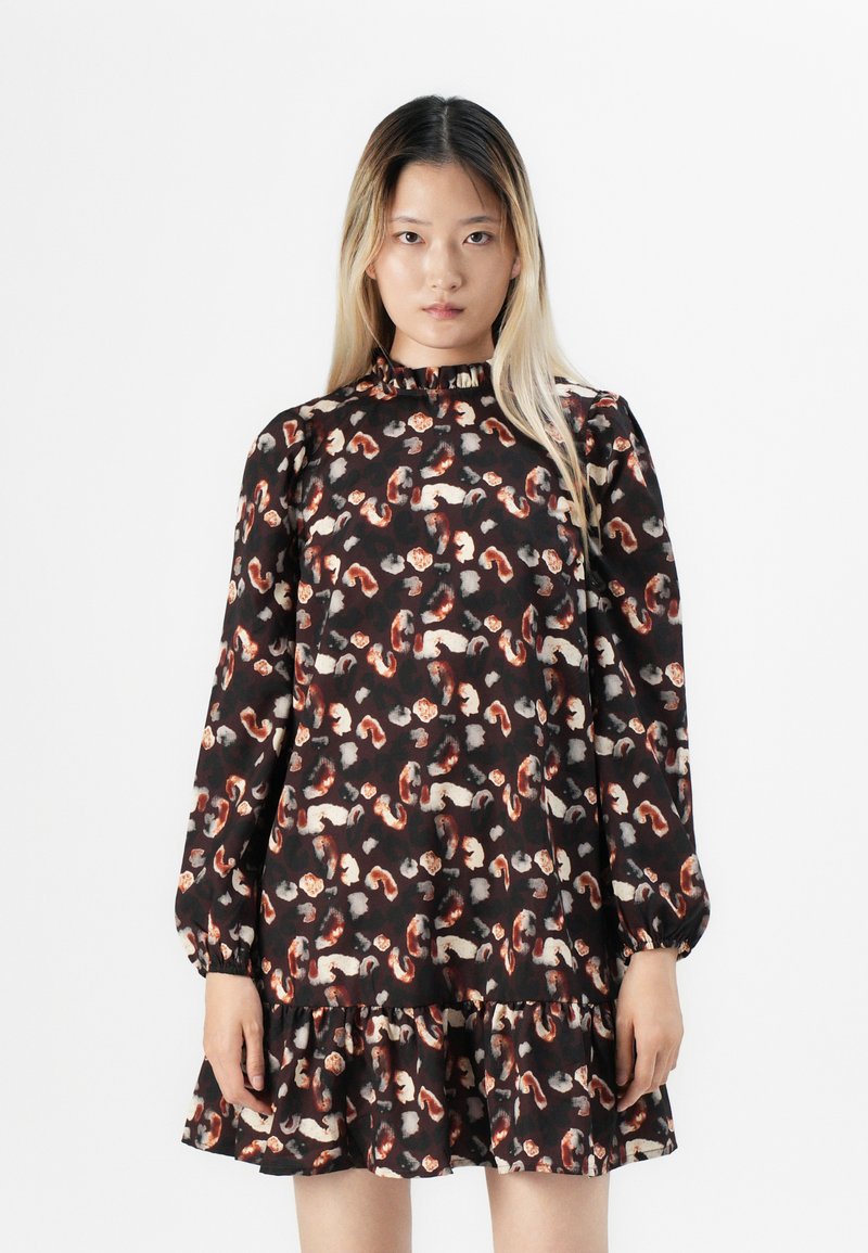 Robe noire à fleurs avec un ourlet volanté, des manches longues bouffantes, un col montant et des motifs multicolores de feuilles et de formes abstraites.
