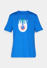 T-shirt en coton bleu présentant le texte "ITALIE" avec un design de logo circulaire en rouge et blanc, accentué par des rayures vertes au col.
