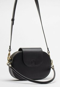 Čierna kožená crossbody taška s okrúhlym tvarom, so zipsom, prednou chlopňou a nastaviteľným popruhom. Zlato-žlté kovanie a embosovaný detail loga.