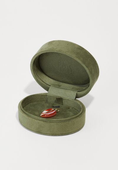 Cutie de bijuterii din suede verde, în formă ovală, deschisă, cu un pandantiv cu dungi roșii și albe în interior, având accesorii din aur și o mică buclă pentru suspendare.