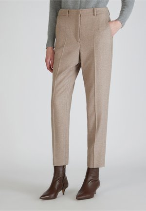 Pantaloni in misto lana beige con vestibilità sartoriale, dotati di tasche laterali e una texture liscia. Abbinati a stivaletti marroni a punta.