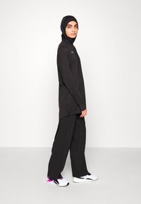 Puma MODEST ACTIVEWEAR WIDE LEG - Treniņtērpa apakšdaļas - black
