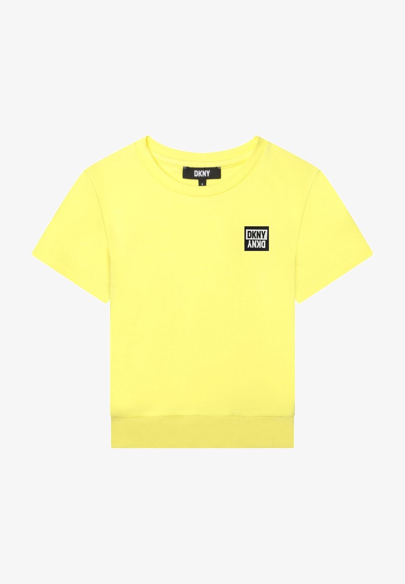 Crop top jaune vif à manches courtes avec col rond et petit écusson noir avec logo DKNY sur le côté gauche de la poitrine.