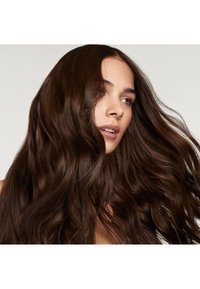 Cheveux longs et ondulés d'une couleur marron foncé, avec une texture brillante, encadrant le visage et montrant des reflets naturels subtils. Teint de peau lisse.