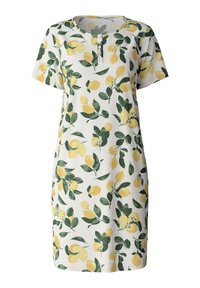 Abito a maniche corte realizzato in tessuto morbido, con un motivo di limoni e foglie gialli e verdi su uno sfondo bianco. Include una patta con bottoni.