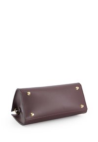 Bordeaux læder clutch med en geometrisk form, gyldne metal accenter og afrundede hjørner. Har fire metalknopper på bunden.