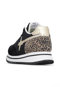 Sneaker in suede nera con tacco metallico dorato e accentuazione in stampa leopardata. Presenta una suola intermedia bianca e una suola esterna nera testurizzata.