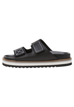 Black leather slide sandals with two adjustable Velcro straps, beige midsole, and white and black layered outsole. Textured finish on straps.