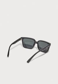 Ochelari de soare dreptunghiulari negri cu lentile închise. Ramele din plastic elegante au accente negre texturate pe brațe. Numele mărcii este gravat pe lateral.