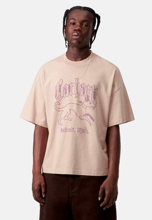 T-shirt oversize beige in cotone con una grafica viola di un cane e la scritta "Carhartt Detroit, Mich." Maniche corte, vestibilità rilassata.