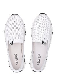 Bílé slip-on boty s perforovaným svrškem, potištěnými černými akcenty na podrážce a texturovanou stélkou. Na jazyku je značka VENEZIA.