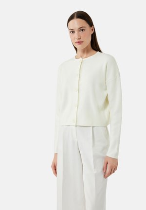 Witte cropped cardigan met een ronde halslijn, lange mouwen en vijf knopen aan de voorkant, gemaakt van zachte stof, gecombineerd met witte broek.