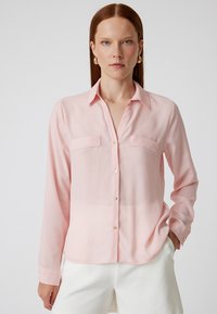 Helle rosa, langärmelige Knopfleiste-Hemd mit zwei Brusttaschen, goldenen Knöpfen und einer glatten, durchsichtigen Textur. Der gefaltete Schnitt ergänzt die Passform.