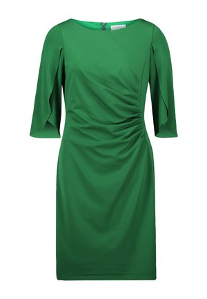 Robe verte en tissu lisse avec un col rond, des manches courtes à volants et un détail froncé d'un côté, créant une silhouette ajustée.