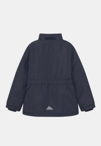 Veste isolante bleu marine à manches longues, taille élastique, col montant et petit triangle réfléchissant sur le bas du dos.