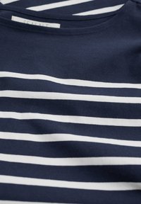 Tumši zils kokvilnas T-krekls ar horizontālām baltām svītrām. Ar apaļu kakla izgriezumu un mīkstu, gludu tekstūru. Uz etiķetes rakstīts "SEASALT".