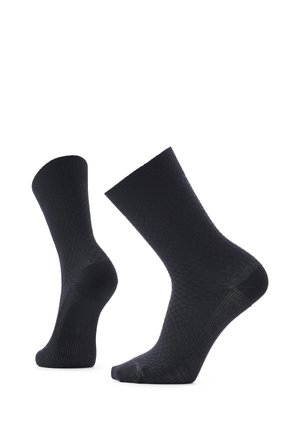 Par de calcetines negros hasta la mitad de la pantorrilla con textura, mostrados en posición vertical sobre un fondo blanco, mostrando detalles del talón y la punta.