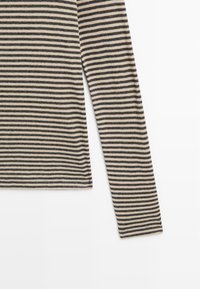 Maglietta a maniche lunghe in maglia con righe orizzontali nere e beige, mostrata piatta su uno sfondo bianco, evidenziando la manica e parte del torso.