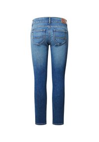 Kitsad teksad keskmises sinises denimis, millel on kulunud efekt. Omavad kahte tagataskut ning pruunist nahast silt vöökohtadel.