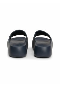 Sandalias de deslizar de color azul marino, hechas de un material suave y duradero, con parte trasera abierta, plantilla contorneada y un diseño minimalista.
