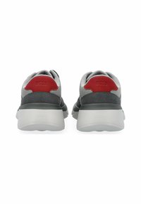 Graue Mesh- und Wildlederschuhe mit roten Akzenten an der Ferse, ausgestattet mit einer dicken weißen Sohle und Logo-Details auf der Rückseite.