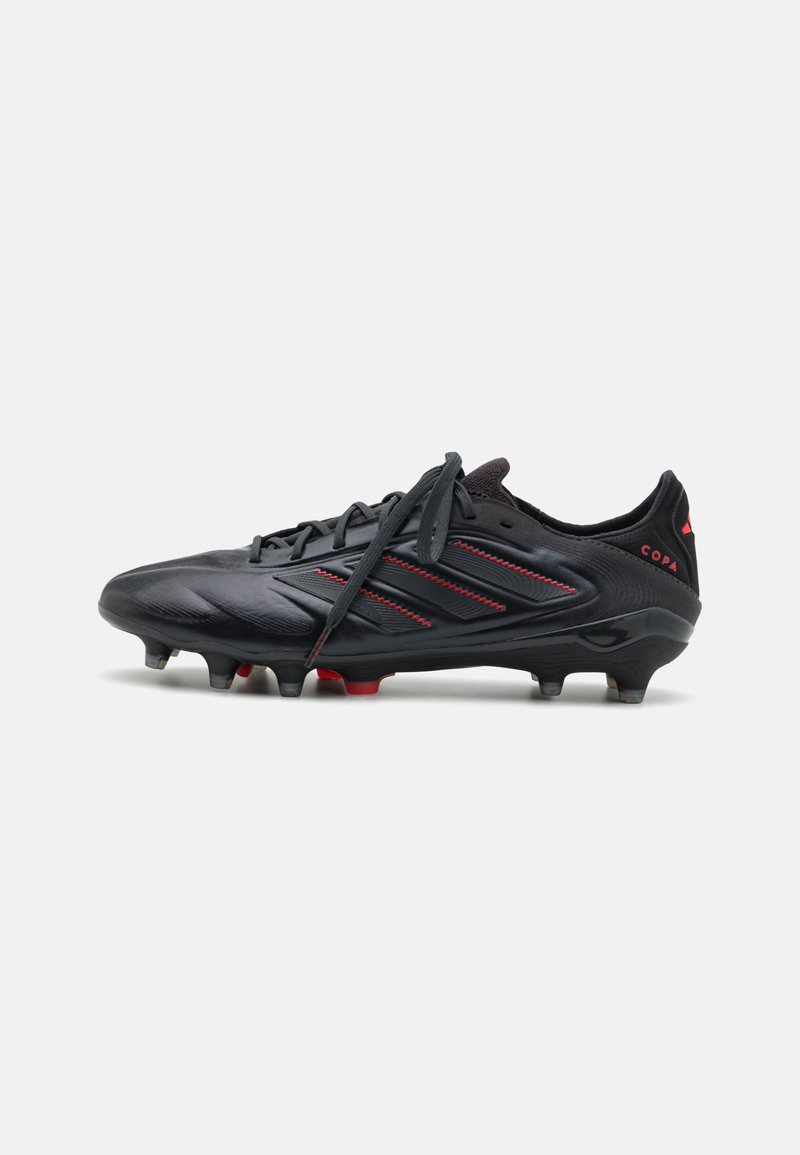 Black soccer cleat with red accents, featuring a streamlined design, lace-up closure, textured upper, and marked studs for traction.