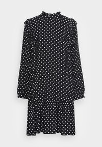 Vestido preto com bolinhas brancas. Gola alta, detalhes em babados nos ombros, mangas longas e saia em camadas. Textura de tecido suave.