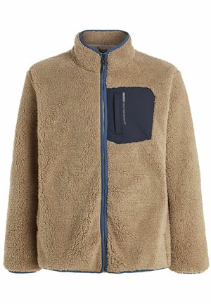 Tan fleece jacket with a high collar, featuring a navy chest pocket and zipper. Textured, soft material with a relaxed fit.