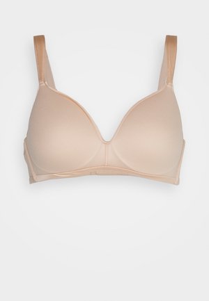 Soutien-gorge beige moulé avec des bretelles ajustables, texture lisse et décolleté plongeant. Pas de matériel visible ni de motifs.