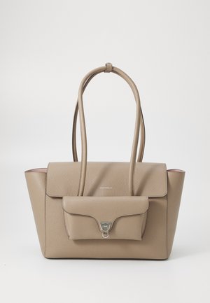 Beige leather handbag with a structured shape, featuring dual handles, a front pocket, and silver hardware accent. Smooth texture and minimal design.