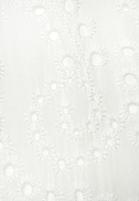 Weißer Stoff mit aufwendiger floraler Stickerei, die erhabene Punkte und kreisförmige Muster zeigt und eine strukturierte sowie detailreiche Oberfläche schafft.