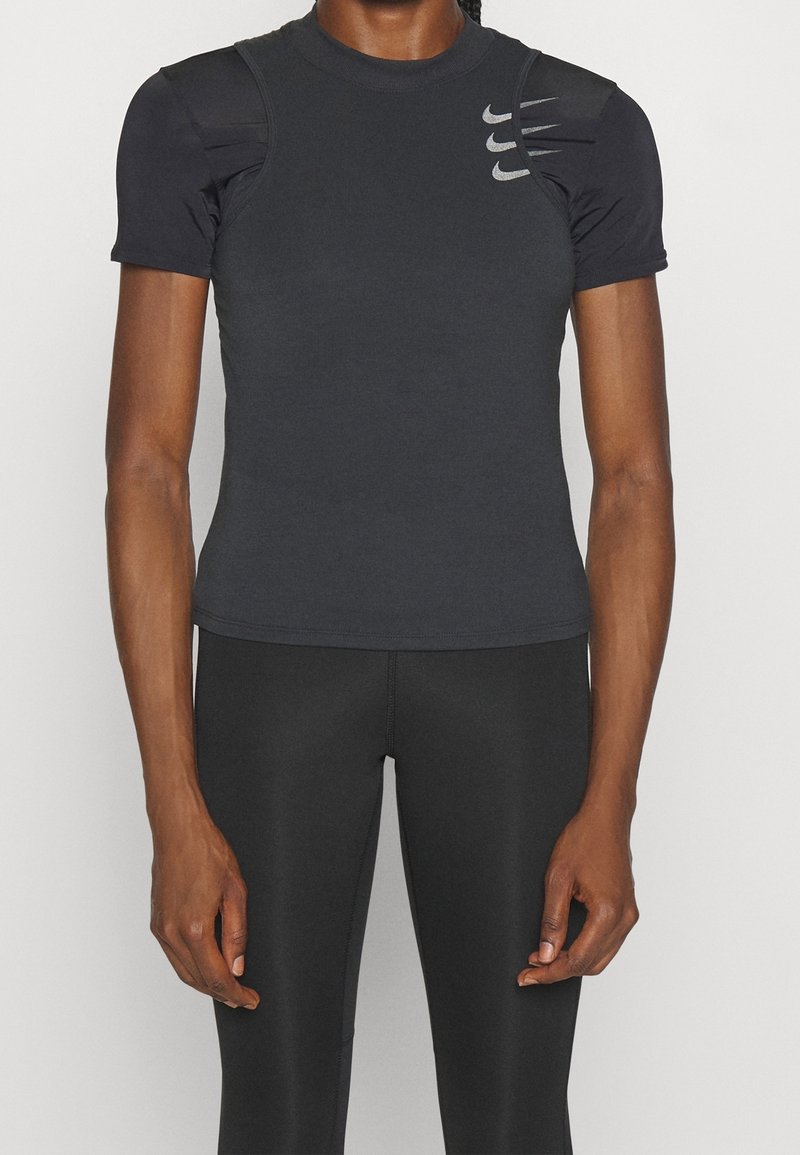 Camiseta deportiva gris oscuro de manga corta, con acentos texturizados en los hombros y el logo de Nike impreso en el pecho. Material liso y ajustado.
