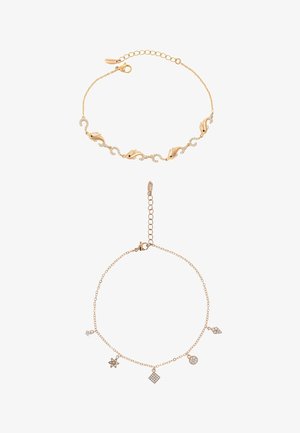 Dwie delikatne bransoletki z złotych łańcuszków, jedna z akcentami delfina i kryształów, druga z pięcioma małymi geometrycznymi i gwiazdkowymi zawieszkami.