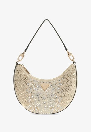 Beige puolikuun muotoinen käsilaukku mustalla hihnalla, kultaisilla lukolla ja pienillä metallisilla niiteillä koristeltu, etuosassa kolmion muotoinen Guess-logo.