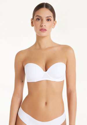 White strapless bra with smooth fabric, molded cups, and a seamless design. Features adjustable hooks at the back for secure fit.