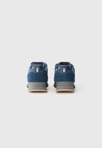 Blauwe suède sneakers met grijze accenten, gewatteerde kraag en gumrubberen zool. Heeft een slank ontwerp en een gestructureerde bovenkant voor comfort.